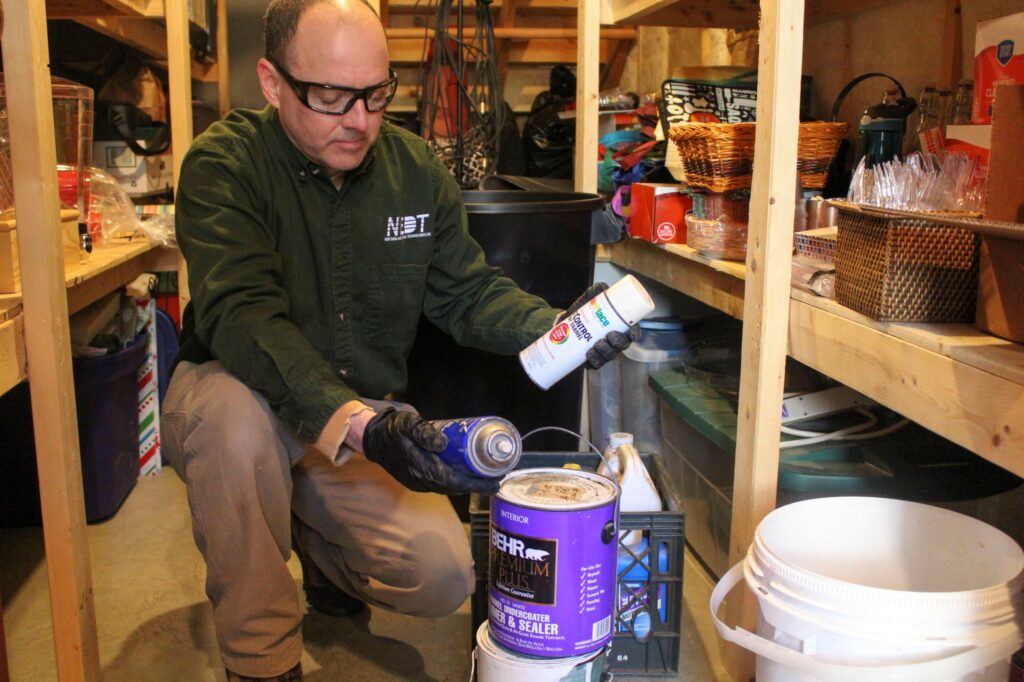 NEDT staff pull household hazardous products out of a garage or shed.