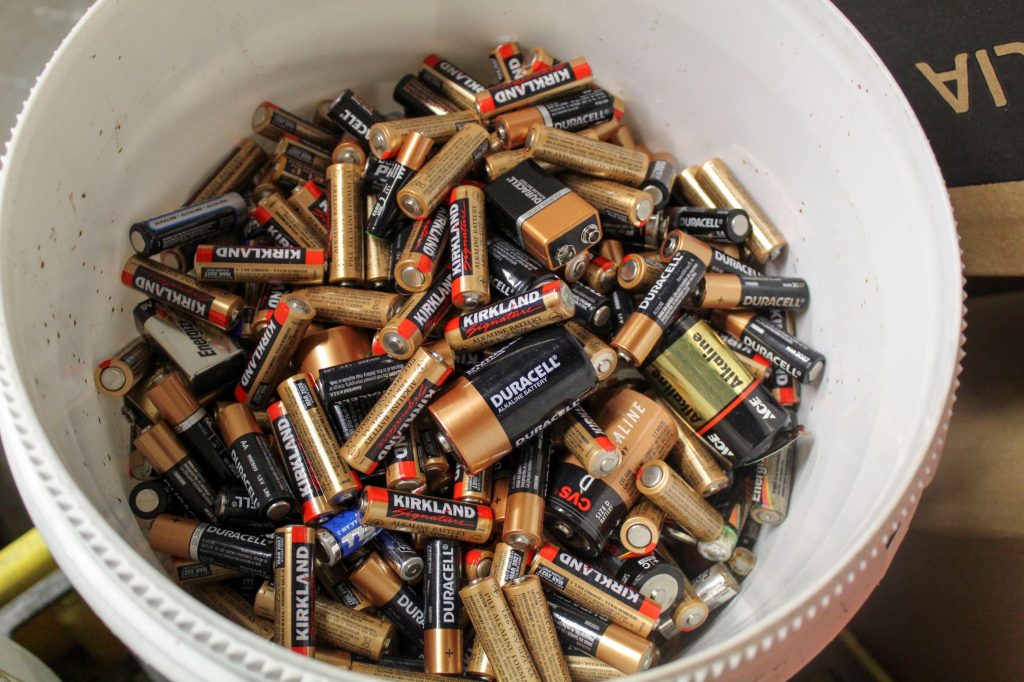 Bucket of household alkaline batteries ready for disposal.