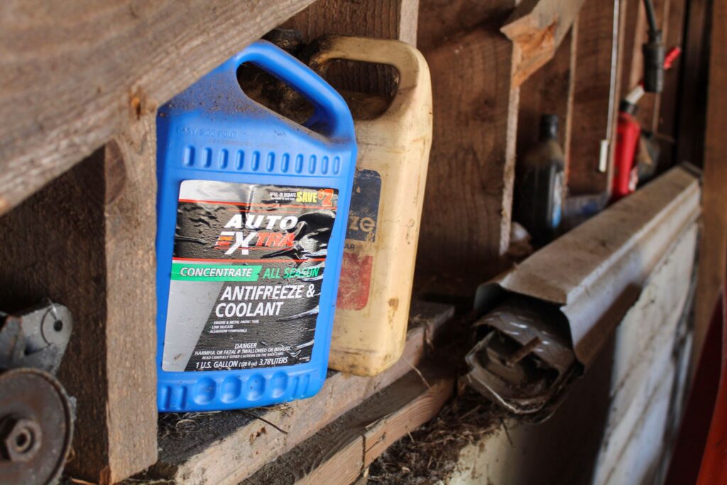 Used Antifreeze coolant sitting in a garage.