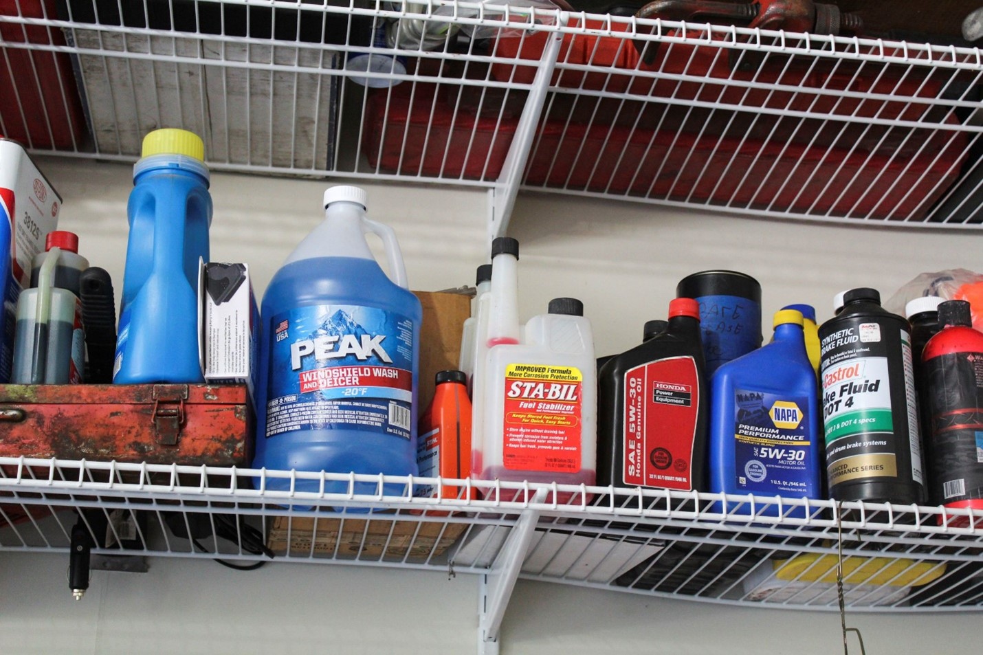 Various bottles of automotive liquids on shelves, such as oil, wiper fluid, and anti-freeze