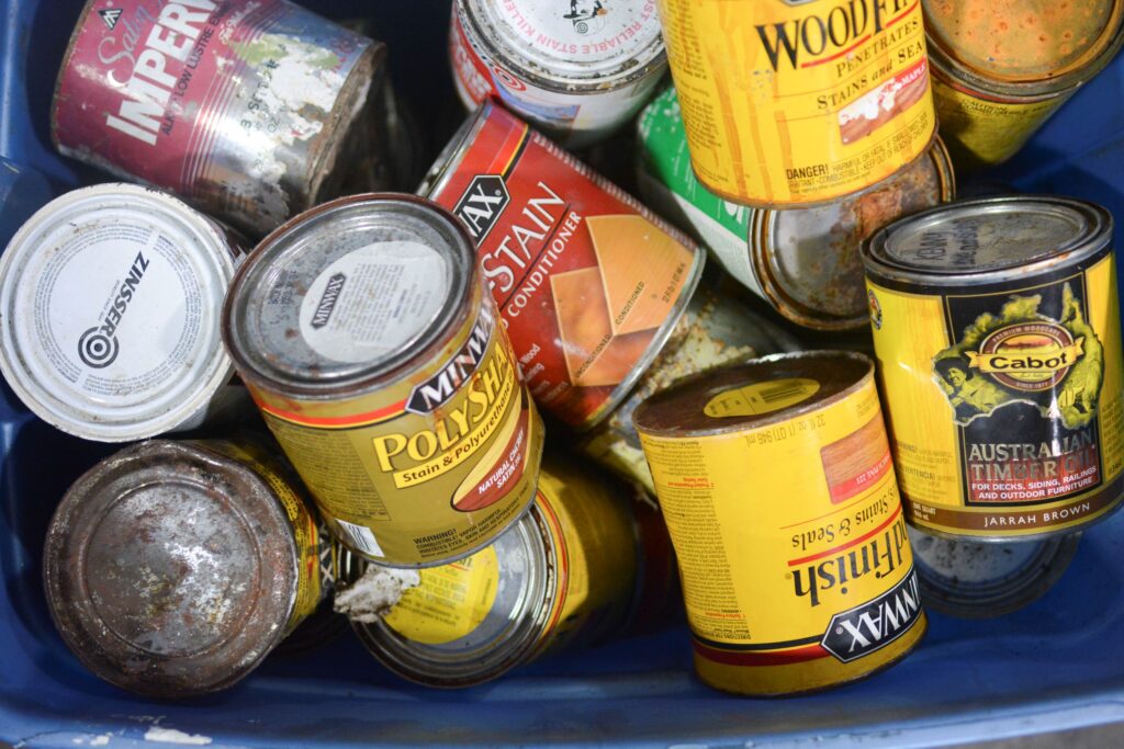 Cans of oil-based paints and stains ready for disposal at an NEDT collection center.