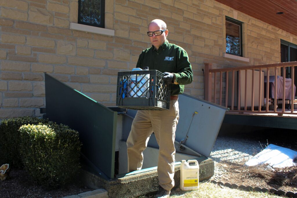 NEDT Technician taking hazardous household products out of a home.