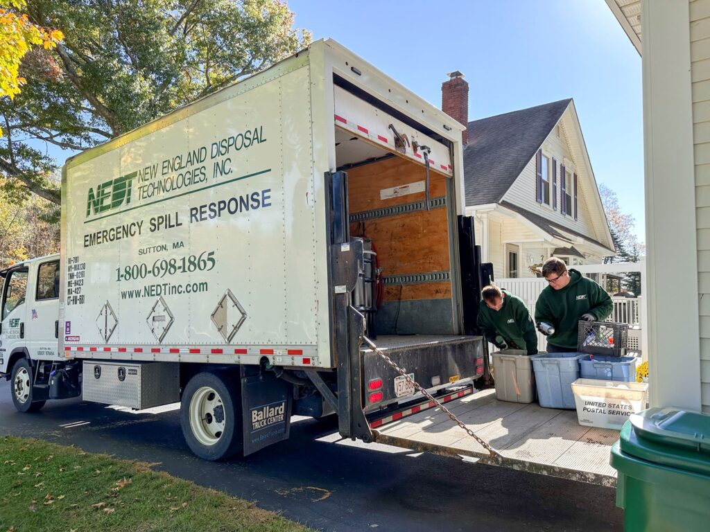 Two NEDT Technicians load household hazardous products into a NEDT truck.