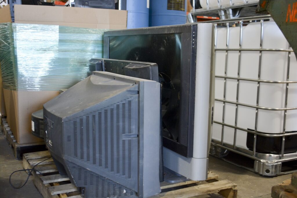 CRT and Flatscreen TVs loaded onto a pallet for disposal.