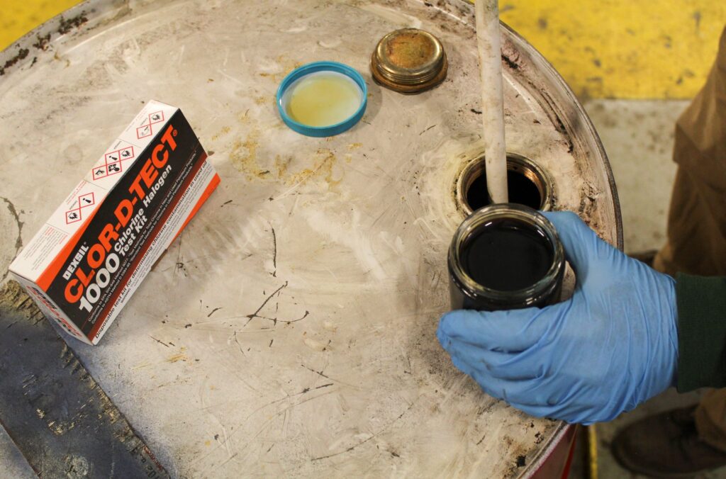 NEDT technician using CLOR-D-TECT on waste motor oil to test for contamination.