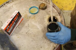 NEDT technician using CLOR-D-TECT on waste motor oil to test for contamination.