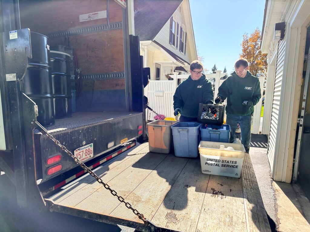 NEDT staff move household hazardous waste out of a house and into an NEDT box truck.