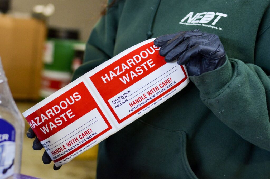 NEDT technician unrolling hazardous waste labels for use.